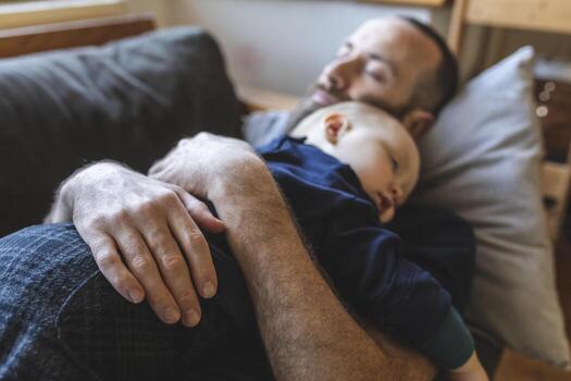 Father and son sleeping together on the sofa photo